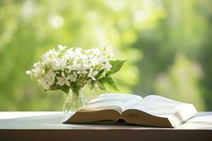 ai generato gelsomino fiori nel un' vaso e Aperto libro su il tavolo, verde naturale sfondo. ai generato foto