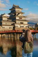 donna turista visitare nel matsumoto, contento viaggiatore assunzione foto matsumoto castello o corvo castello. punto di riferimento e popolare per turisti attrazione nel matsumoto, nagano, Giappone. viaggio e vacanza concetto