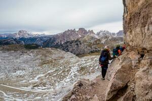 persone arrampicata su un' attraverso ferrata itinerario nel il montagne. avventura montagna attività. nazionale parco tre cime di lavaredo, dolomiti Alpi, Sud tirolo, Italia foto