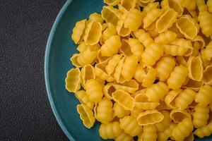 crudo duro Grano Gnocchi pasta con sale e spezie nel un' ceramica piatto foto