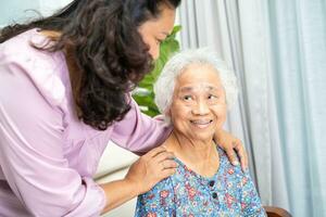 badante Aiuto e supporto asiatico anziano donna con amore e cura nel casa. foto