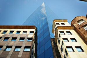 bicchiere edificio con trasparente facciata di il edificio e blu cielo. strutturale bicchiere parete riflettendo blu cielo. astratto moderno architettura frammento. contemporaneo architettonico sfondo. foto