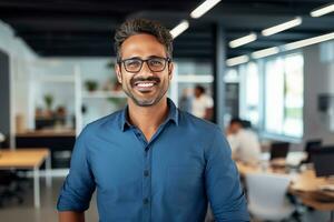 ai generato ritratto di un' giovane indiano maschio progettista, ingegnere, architetto chi è indossare bicchieri e un' blu camicia sorridente in piedi nel il ufficio e guardare a il telecamera foto