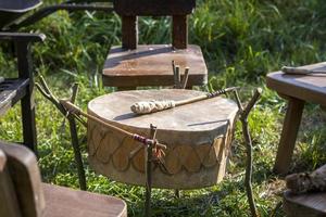 tamburo indiano nordamericano fatto di rawhide con pipistrello pronto per suonare foto