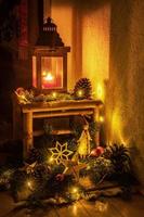 decorazione natalizia con candela, rami di abete, babbo natale e palline di vetro davanti a uno sfondo scuro foto