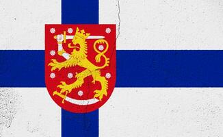 bandiera e cappotto di braccia di repubblica di Finlandia su un' strutturato sfondo. concetto collage. foto