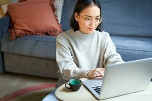 ritratto di Lavorando donna d'affari utilizzando computer portatile, opera su a distanza. coreano ragazza con computer, negozi in linea foto