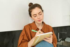 ritratto di donna disegno nel taccuino, scrittura giù sua pensieri su carta foto