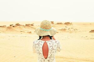 femmina turista visitare sedersi su panchina prendere foto di fossile dune strutture. abu dhabi, emirati arabi uniti. famoso viaggio destinazione al di fuori capitelli