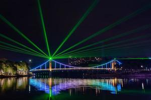 di notte, il ruscello riflette le luci colorate sul ponte foto