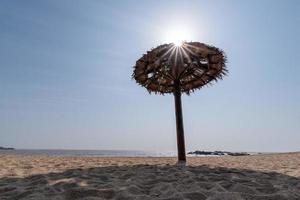 ci sono ombrelloni in erba sulla spiaggia in estate foto