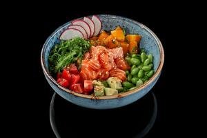 colpire ciotola di salmone, Mango, pomodori, avocado, fagioli di soia fagioli, wakame alga marina, ravanello foto