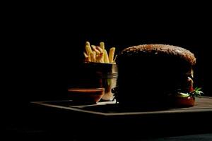 silhouette di Hamburger con francese patatine fritte e salsa foto