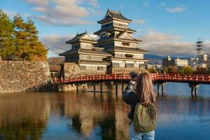 donna turista visitare nel matsumoto, contento viaggiatore assunzione foto matsumoto castello o corvo castello. punto di riferimento e popolare per turisti attrazione nel matsumoto, nagano, Giappone. viaggio e vacanza concetto