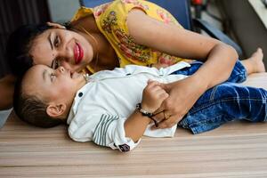 amorevole mamma trasporto di sua bambino a casa balcone. luminosa ritratto di contento mamma Tenere bambino nel sua mani. madre con sua poco 1 anno vecchio figlio. foto