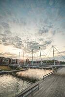 pedone e bicicletta ponte al di sopra di il porto nel il centro di almere durante tramonto. olandese moderno e utilitaristico costruzione foto