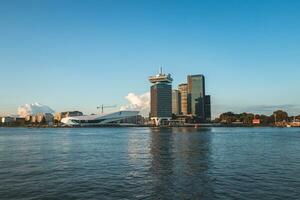 principale turista centro nel amsterdam, il Olanda, un' Visualizza di il totale città su il altro lato di il canale durante tramonto foto