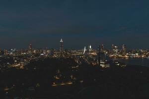 notte aereo Visualizza di il insonne città di rotterdam e architettonico edifici. raggiante grattacieli e il famoso erasmusbrug ponte. il moderno città di il Olanda foto