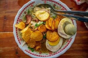 indonesiano pollo la minestra o soto ayam è un' tradizionale indonesiano cibo con un' giallastro sugo di carne. foto