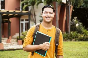 giovane ispanico alunno sorridente contento indossare un' zaino a il Università città universitaria. foto