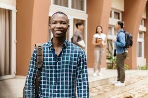 nero alunno sorridente con fiducia Tenere libri su il città universitaria Università. foto