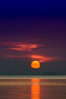 grande sole e arancia nube nel tramonto cielo su il lago. foto