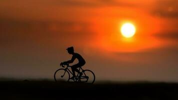 sagome ciclisti su il spiaggia a tramonto. foto