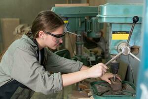 un' giovane femmina falegname Lavorando progetto nel sua officina. femmina falegname fabbricazione di legno arredamento. foto