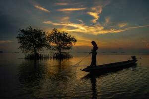 silhouette pescatore con tramonto cielo su il lago. foto