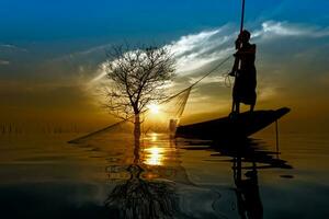 silhouette pescatore con tramonto cielo su il lago. foto