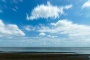 blu cielo e mare con movimento bianca nuvole. foto
