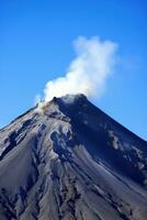 ai generato il maestoso energia e bellezza di un' torreggiante vulcano impostato contro un' chiaro blu cielo. foto