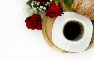 romantico prima colazione. caffè con un' brioche con un' mazzo di Rose su un' bianca sfondo. foto