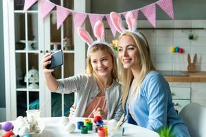 mamma e figlia si fanno selfie nelle orecchie del coniglietto pasquale. foto