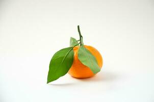 uno mandarino con verde le foglie su un' bianca sfondo foto