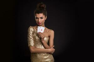 donna vincente - giovane donna nel un' di classe oro vestito Tenere Due assi, un' poker di assi carta combinazione. foto