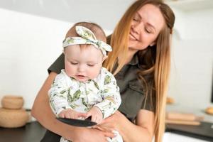 concetto di fotografia di mamma e bambino felice, mamma carina e bella che tiene in braccio la sua bellissima piccola figlia foto