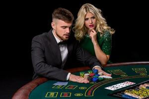 Visualizza di giovane, fiducioso, uomo con il signora mentre lui è giocando poker gioco. foto