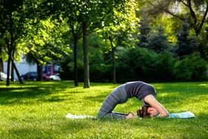 giovane donna fare yoga esercizi nel il estate città parco. foto