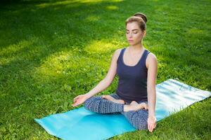 giovane donna fare yoga esercizi nel il estate città parco. foto