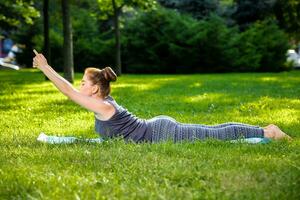 giovane donna fare yoga esercizi nel il estate città parco. foto