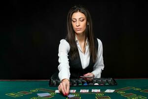 il bellissimo ragazza, rivenditore, dietro a un' tavolo per poker foto