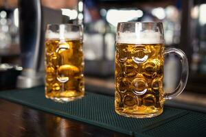 Due bicchieri di birra su un' bar tavolo. birra rubinetto su sfondo foto