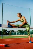 giovane, bellissimo ragazza atleta nel abbigliamento sportivo fare riscaldamento a il stadio foto