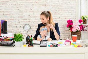 mamma e donna d'affari Lavorando con il computer portatile computer a casa e giocando con sua bambino ragazza. foto