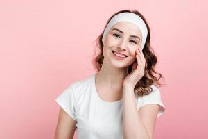 ragazza sorridente in posa con fascia. isolato su sfondo rosa. foto