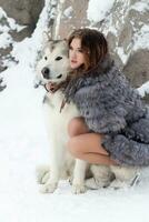 giovane donna con lupo cane nel neve foto