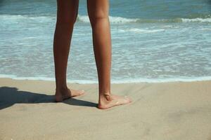 femmina piedi nel il sabbia di mare foto