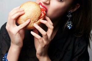 ragazza mangiare un' grande Hamburger, studio foto