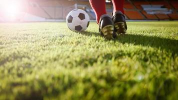 giocatore di calcio o di calcio in piedi con la palla sul campo per calciare il pallone da calcio allo stadio di calcio